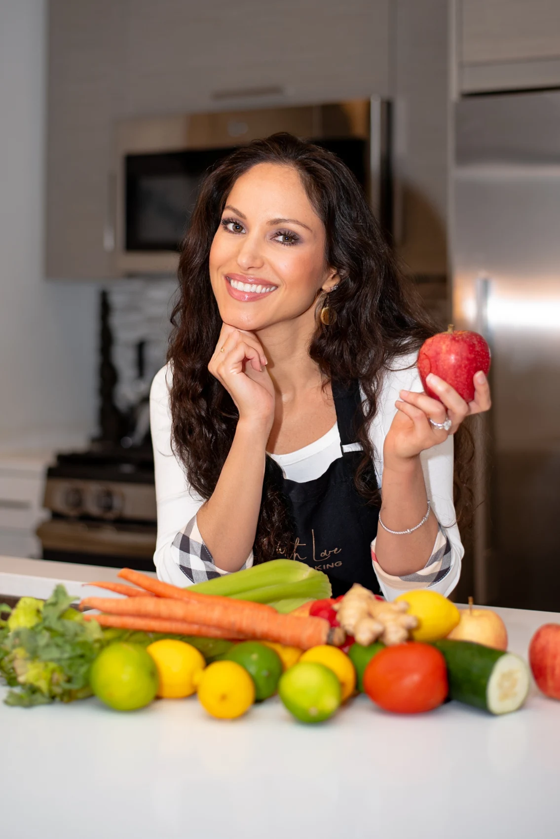 Cheryl Martinez in her kitchen with colorful fresh vegetables